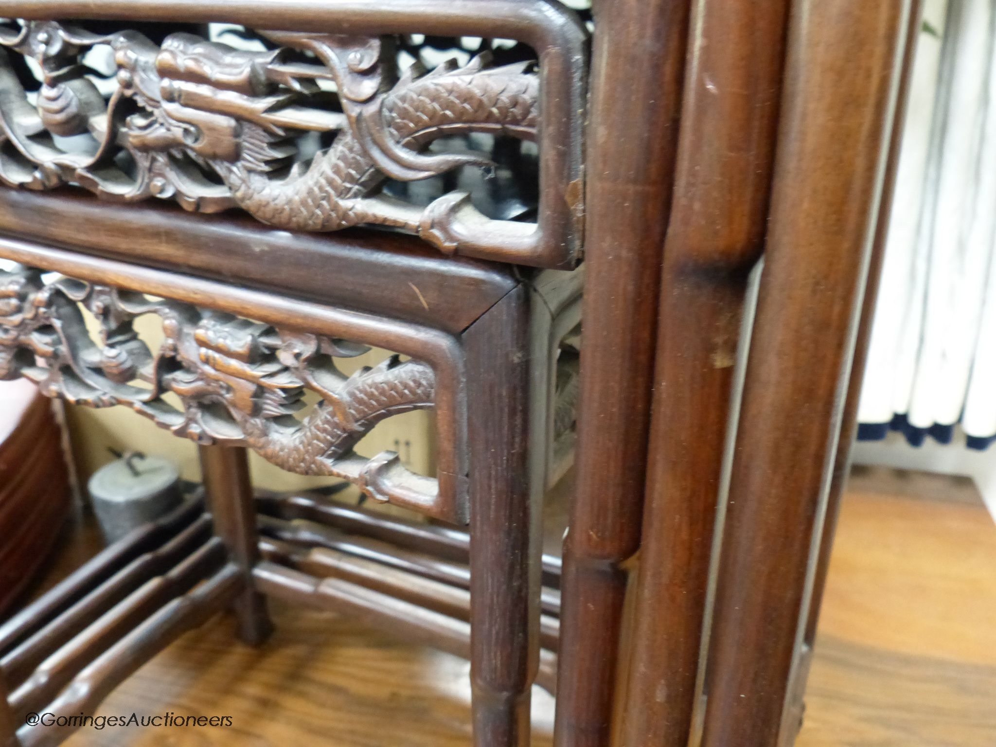 A Chinese nest of four hongmu tables, early 20th century, with a dragon carved freeze, largest table 50.5 cm high, 37 cm deep, 72 cm high